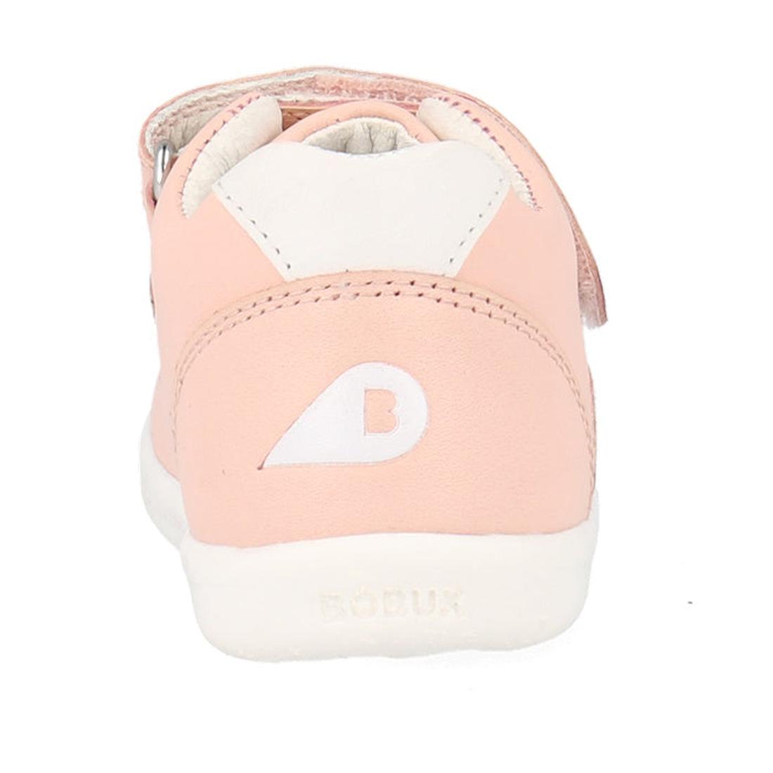 The back view of the Bobux Kids IWalk IW Comet Sneaker in Seashell Pink/White shows a pink and white retro-inspired design with a B logo on the heel, "BOBUX" embossed on the flexible white sole, and a light interior lining complementing the leather upper.