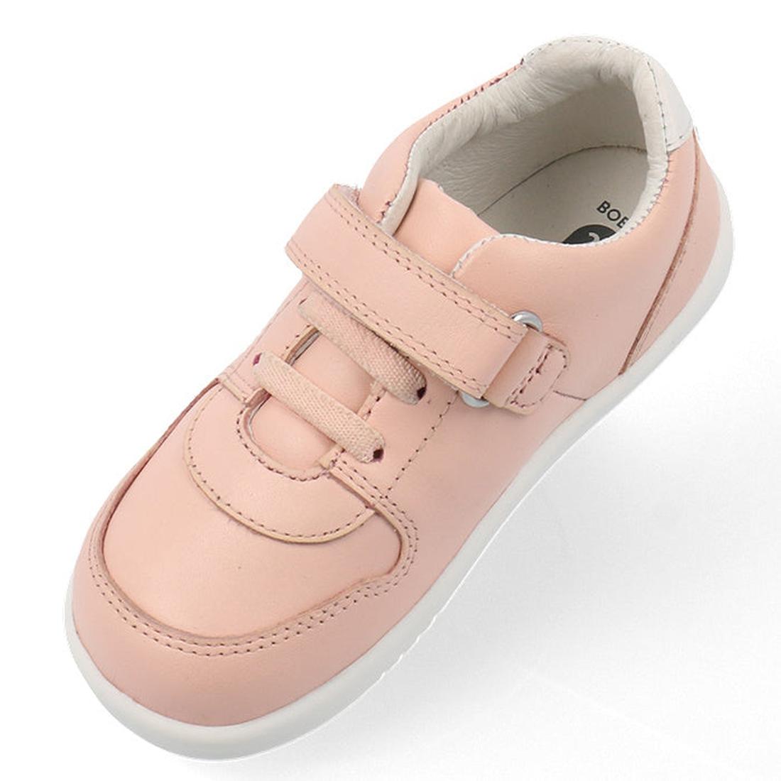 The Bobux Kids IWalk IW Comet Sneaker in Seashell Pink/White features a leather upper, flexible white sole, hook-and-loop strap, and pink laces, shown as a single children's sneaker on a white background., 9420075706286, 9420075706293, 9420075706309, 9420