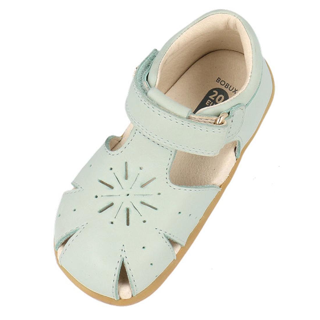 The Bobux Step Ups Compass Mist Aqua 734905 is a toddler girls' first walker sandal in light blue, featuring a closed toe, starburst cut-out design, adjustable hook-and-loop strap, beige lining, and light brown sole—ideal leather shoes for toddlers., 9420