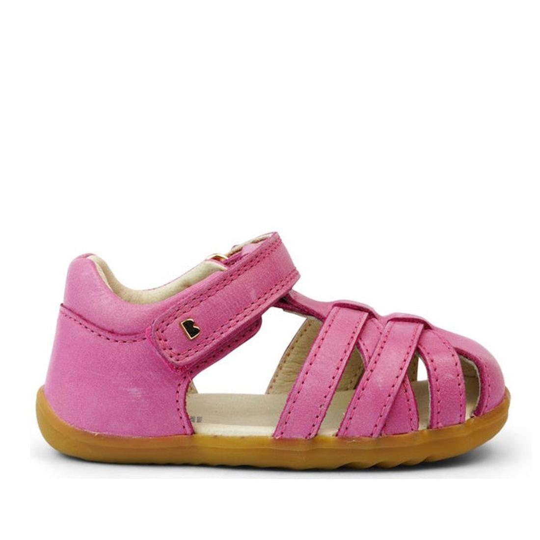 The Bobux Step Up Toddlers Cross Jump Sandal Bright Pink 731109 features pink leather, a tan rubber sole, open toe, Velcro strap, multiple front straps, and a metallic heart detail—perfect as a first walker., 9420068531420, 9420068531437, 9420068531444, 9