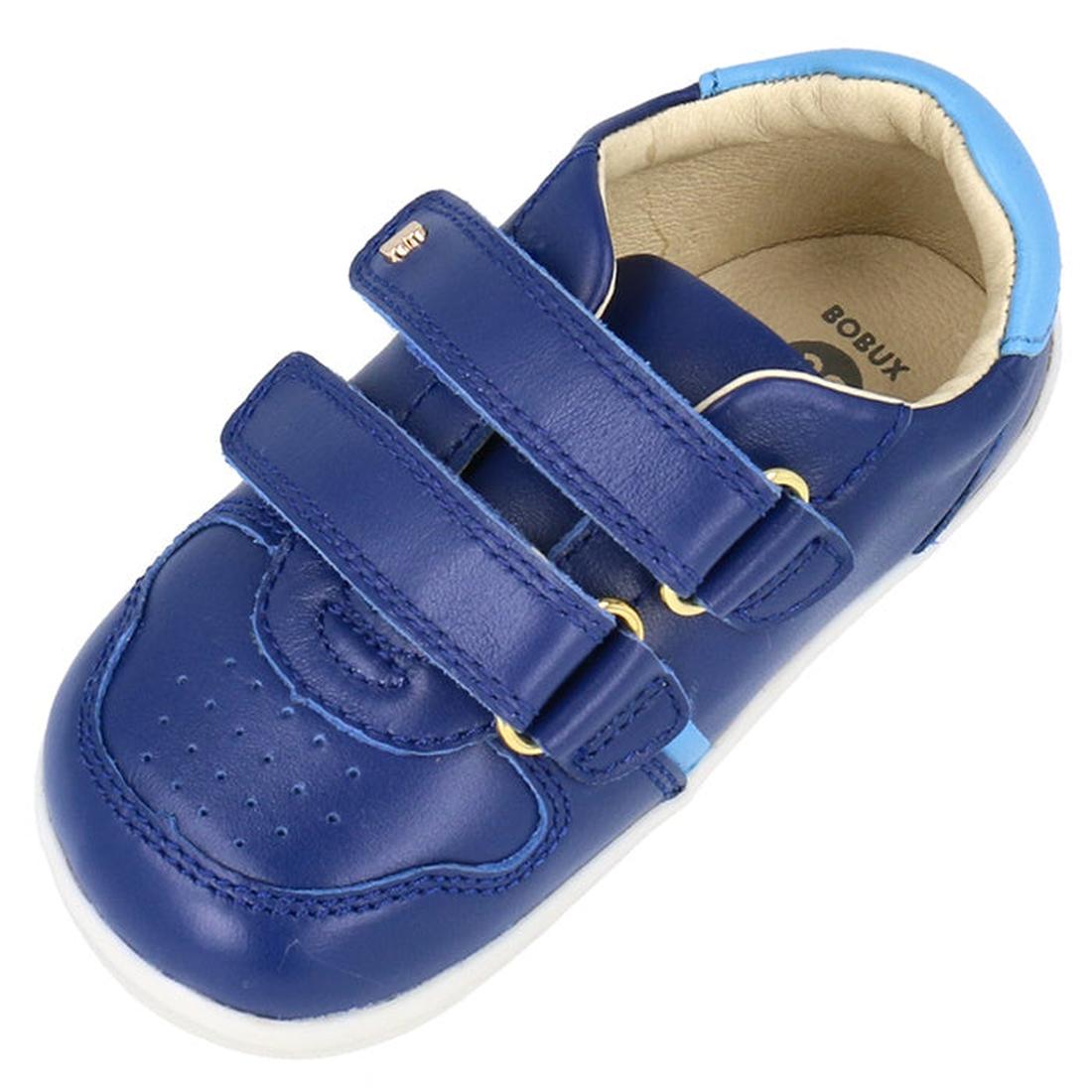 The Bobux Step Up SU Riley Sneaker Blueberry is a single blue leather children’s shoe with double straps, light blue accents, and a white rubber sole. Its vintage-look unisex design features the BOBUX logo on the insole for classic appeal., 9420075794962,