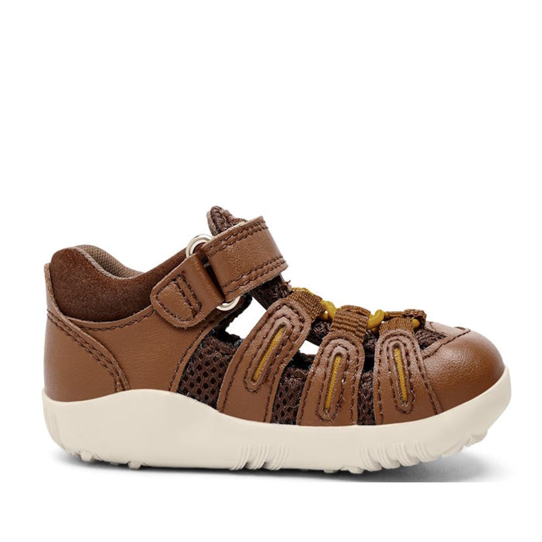The Bobux Step Up Summit Caramel Toffee Sandal 731609 is a brown, water-friendly leather toddler sandal with closed toe, velcro strap, mesh sides, yellow elastic laces, and white rubber sole—ideal for first walkers and shown in profile on a plain backgrou