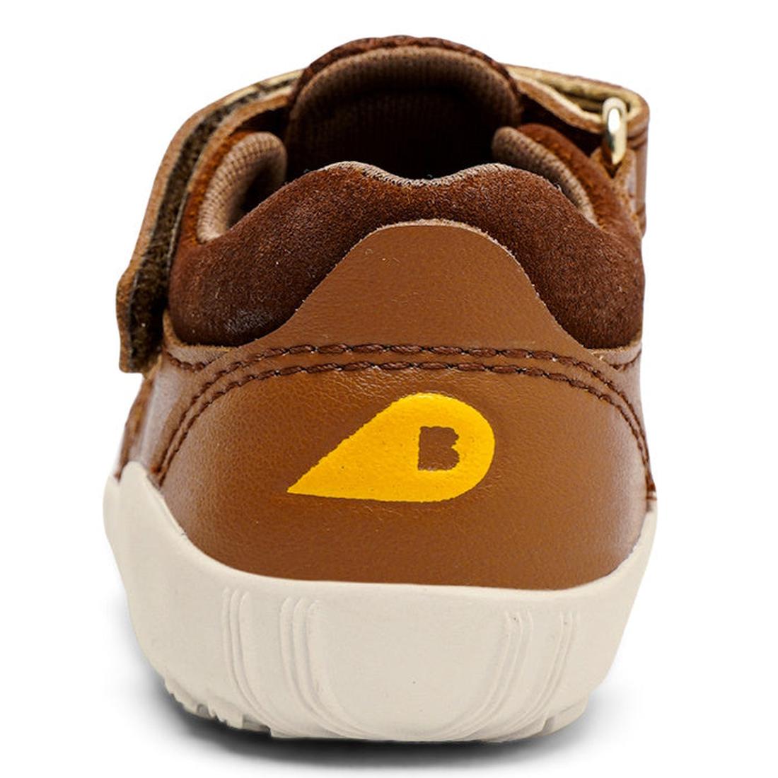 A close-up of the Bobux Step Up Summit Caramel Toffee Sandal 731609 shows its brown back with a yellow teardrop logo featuring a small B on the heel, white sole, and suede-like brown trim., 9420071313891, 9420071313907, 9420071313914, 9420071313921