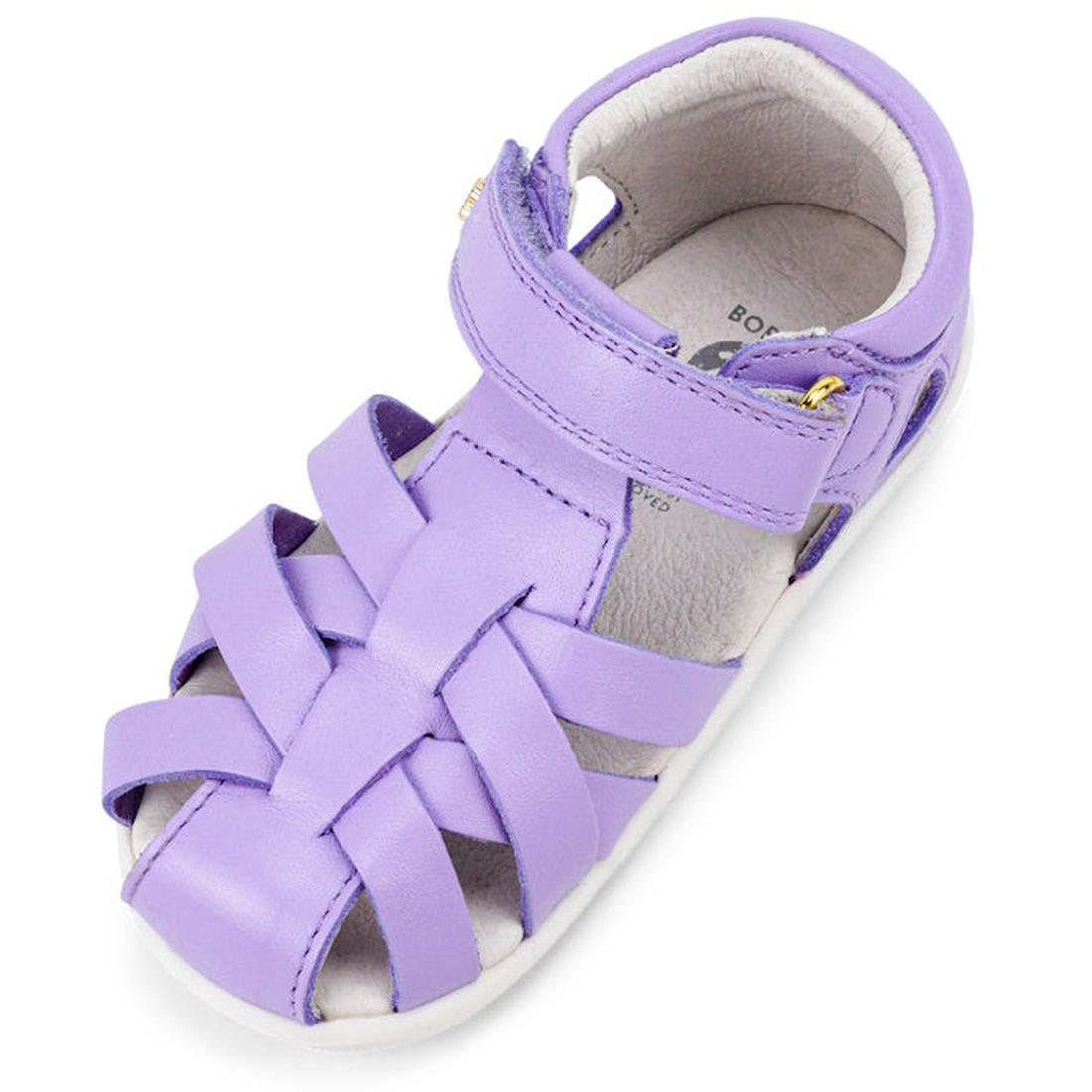 The Bobux Step Up Tropicana II Lilac Toddler Girls Sandal 732315 features woven Quick Dry straps, a closed heel and toe, an adjustable velcro ankle strap, plus a soft white inner lining and sole. Sold as a single lavender-colored sandal for children., 942
