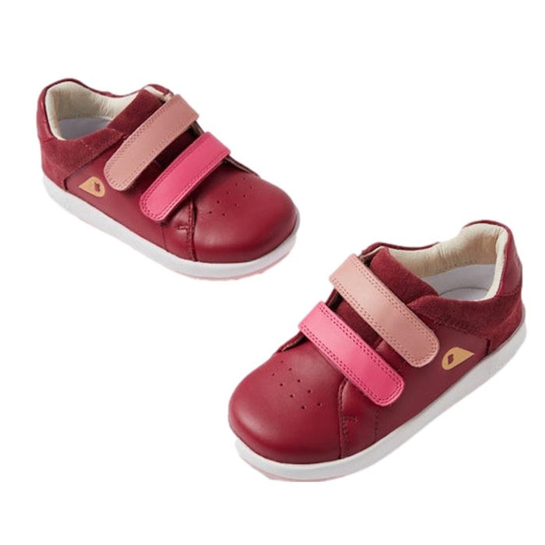 The Bobux Kid+ Breakpoint Sneaker Cranberry 852904 features cranberry red leather, two hook-and-loop straps in pink and light pink, white soles, and a gold triangular side logo—perfect stylish sneakers for little feet.