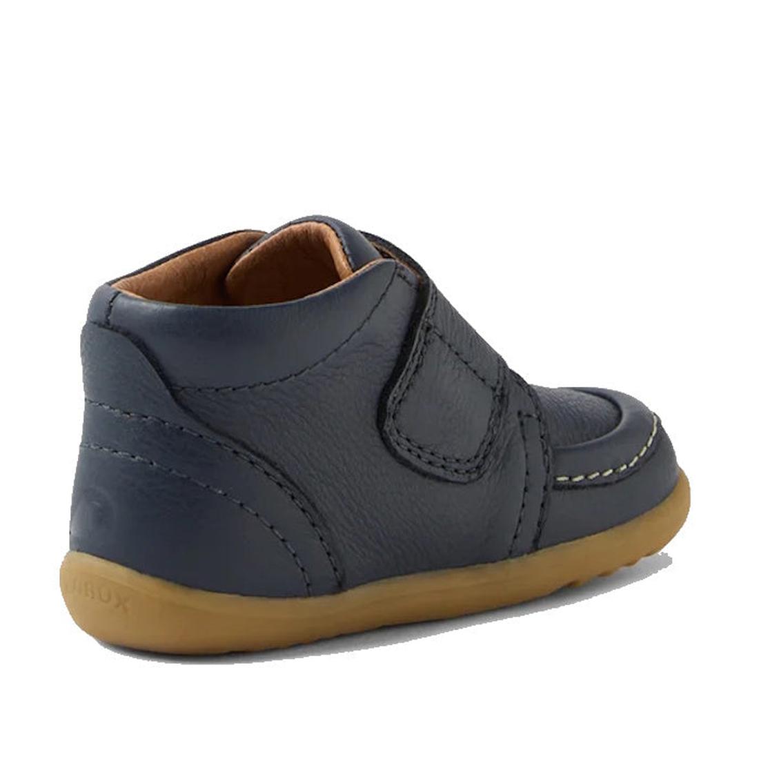 The Bobux Step Up First Walkers Grover Leather Boot in navy is shown from a rear side angle, featuring a tan rubber sole, visible stitching, and a Velcro strap—ideal first shoes for babies—on a white background., 9420074831750, 9420074831767, 942007483177