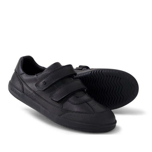 The Bobux Kid+ Black School Leather Shoe Traverse Trainer features two adjustable straps—one upright, one sideways—and a durable tread pattern, making it the perfect sneaker-style school shoe for kids.