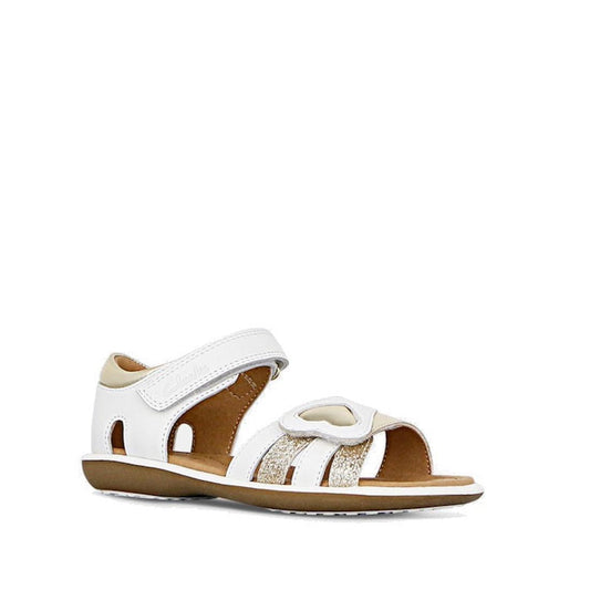 Clarks - Girls Pippa White Leather Sandals E Average Width features a white and beige leather upper, adjustable hook-and-loop strap, glittery accents, heart detail on top, and brown sole, shown against a plain white background.