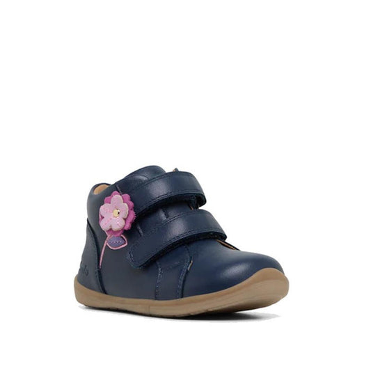 The Clarks Kids Manuela Leather Boot in navy features two velcro straps, a pink and purple flower on the side, and a light brown rubber sole, offering comfortable footwear for children. Shown against a white background.