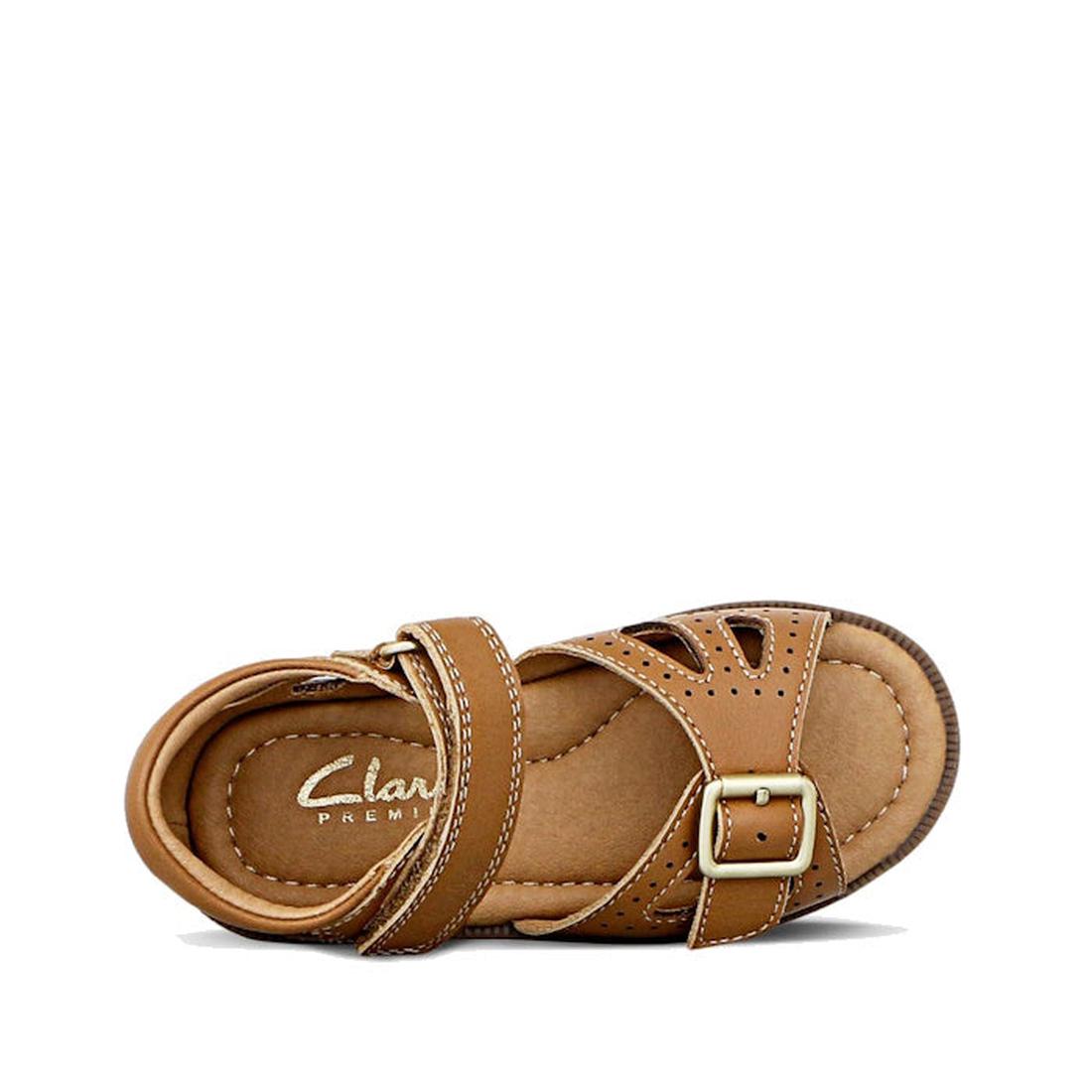 The Clarks Carrie Tan Leather Girls Sandal, shown from above on a white background, features a single brown sandal with cushioned insole, ankle strap, side buckle, and decorative stitching—perfect for everyday wear., 9336078210852, 9336078210890, 93360782
