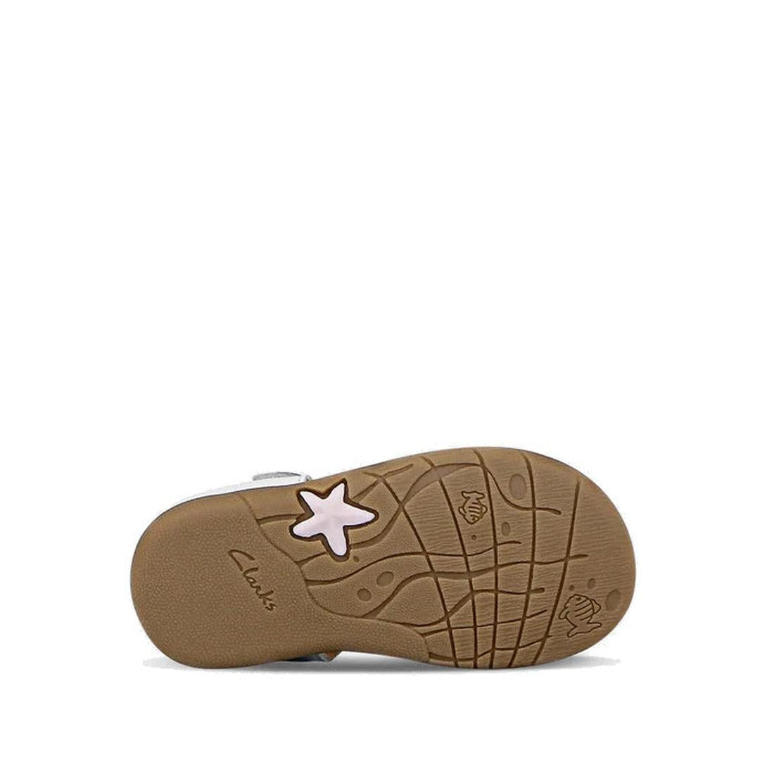 The image shows the sole of the Clarks Saskia White Toddlers Leather Sandal (E width). The brown rubber sole features a pink star, wave-like patterns, a small fish design, and the Clarks logo. These sandals have an adjustable strap for comfort and fit., 4