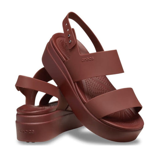 A pair of Crocs Sandal Wedge Dark Clay Red Brooklyn Low for women, featuring two wide straps, an ankle strap, Crocs logo on the side, and cushioned LiteRide foam for all-day comfort.