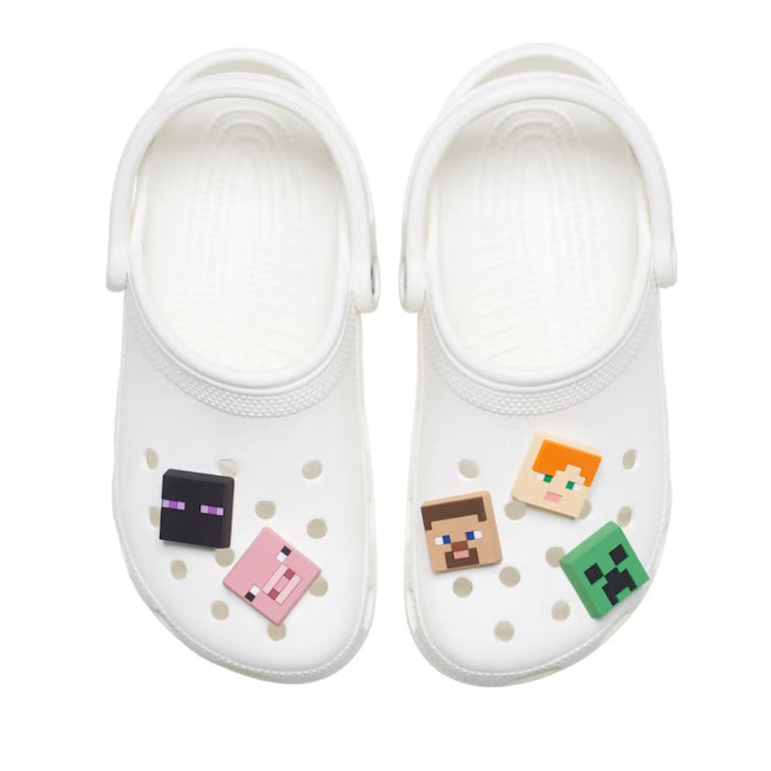 A pair of white Crocs decorated with the Crocs Jibbitz 5 Pack - Minecraft, featuring pixelated faces of Steve, Alex, Creeper, and Enderman attached to the shoe holes., 196265283828