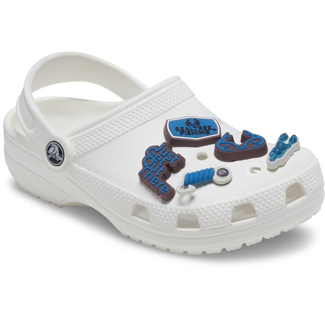 A white Crocs shoe decorated with the Crocs Jibbitz 5 Pack - Realtree Aspect, featuring outdoor-themed charms like a blue sign, hiking boot, dumbbell, and fishing accessories. The Crocs logo appears on the heel strap., 196265422487