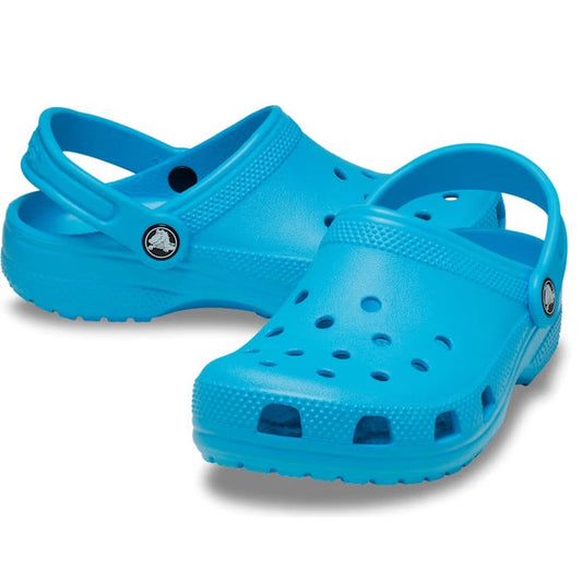 The Crocs Kids - Classic Clog K Venetian Blue Toddlers are bright blue clogs with ventilation holes and adjustable heel straps, made from cushy Croslite foam, shown on a white background.
