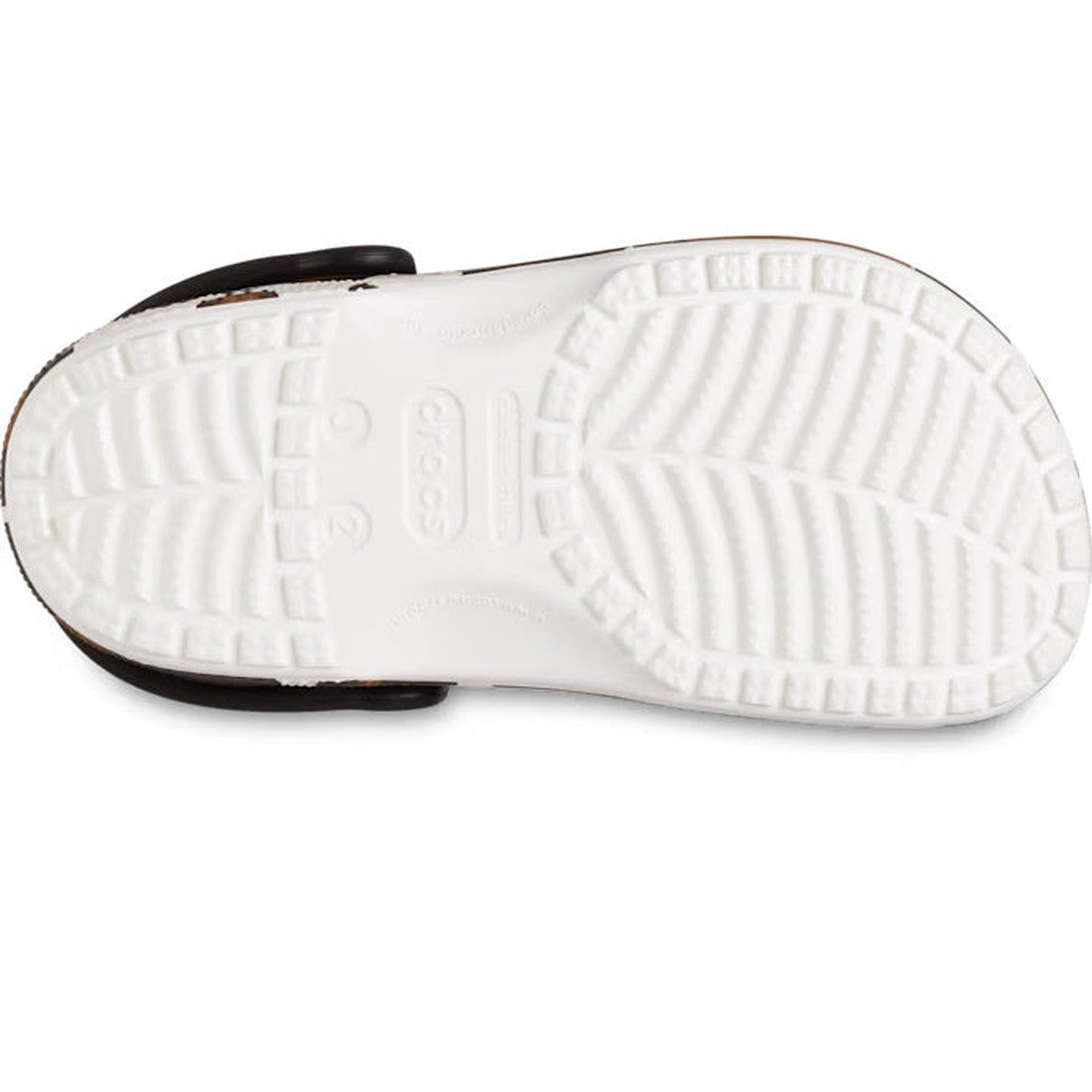 The image shows the white sole of Crocs Kids - Youths Classic Clog K Cow Print White Sandals, viewed from the bottom. The textured tread pattern provides grip, and the Crocs logo is visible in the center., 196265869510, 196265869527, 196265869534, 1962658