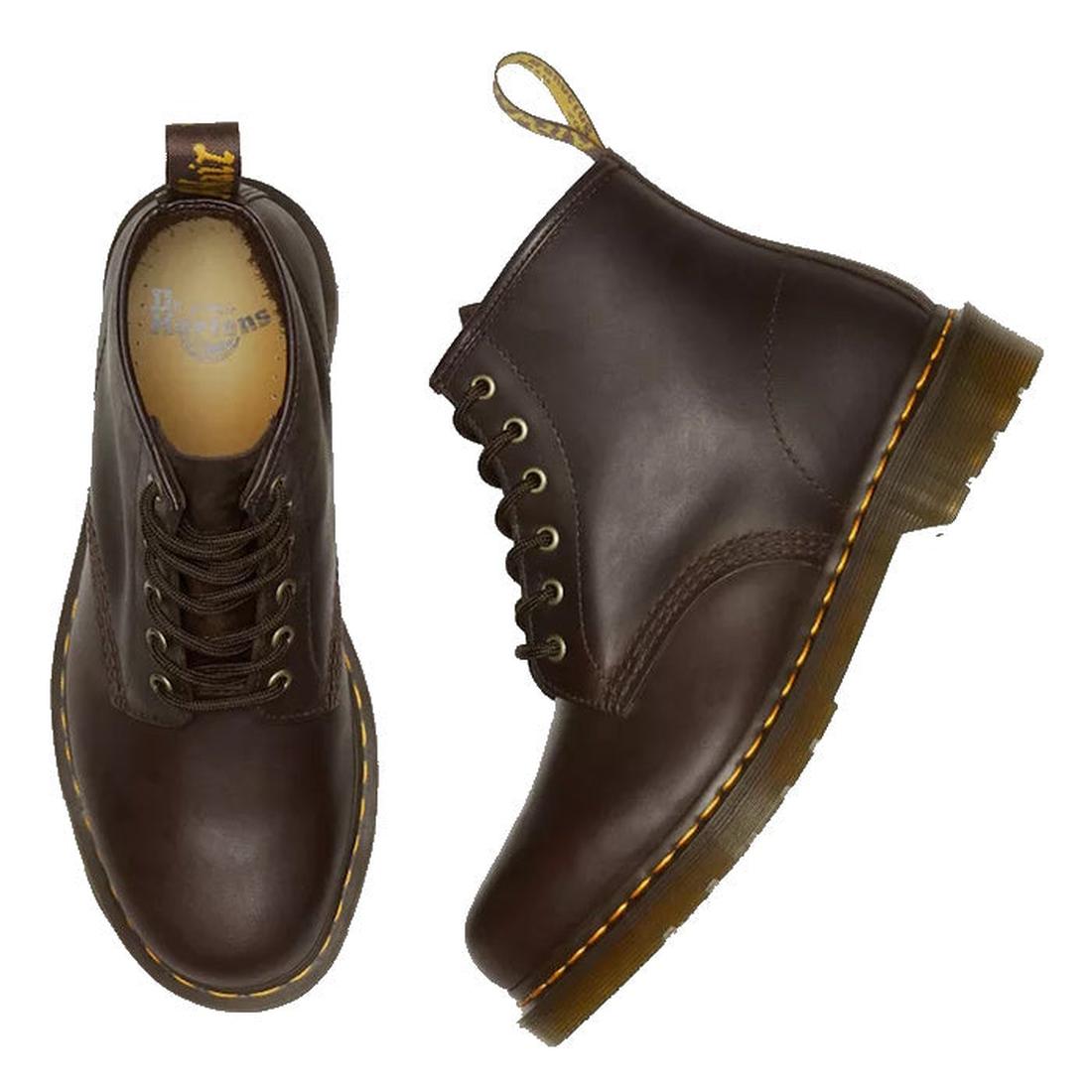 A flay lay of a pair of Dr Martens 101 6 eye boots in brown leather boots. Showing the right foot top down with the dr martens logo on the foot bed, the left foot showing the outer foot side on a white background.,
190665488418,
190665488425,
190665488449