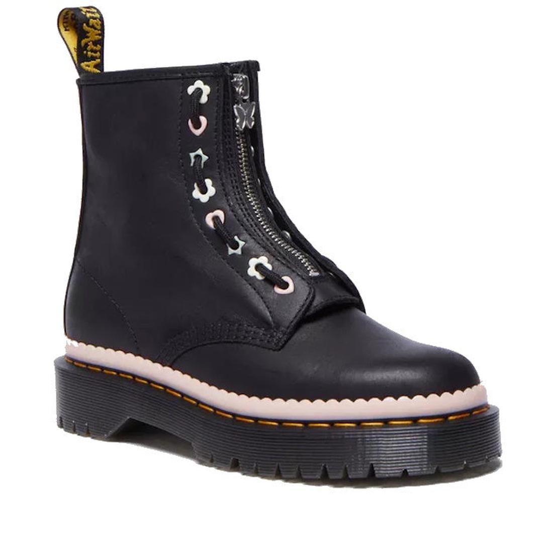A Dr Martens black leather ankle boot with a front zipper closure and decorative pastel-colored star and crescent-shaped eyelets. The boot features a thick black sole (3.3cm height) with signature yellow stitching and a scalloped pink midsole detail. A ye