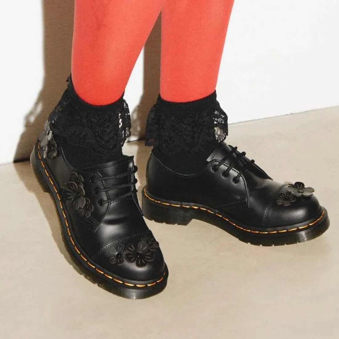 A customer wears Dr Martens 1461 Flower Oxford in shiny black leather with 3D flowers, lace-up closure, and sturdy sole.  ksnz, 190665638967, 190665638974, 190665638981, 190665639001, 190665639018, 190665639025