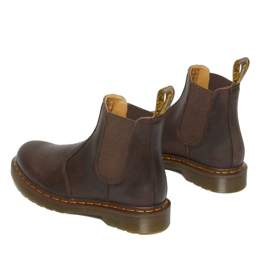 A pair of Dr. Martens 2976 YS Chelsea Boots in Crazy Horse Brown leather with yellow stitching, elastic side panels, and grooved soles is angled to highlight the back and sides., 190665464962, 190665464979, 190665464986, 190665465006, 190665465013, 190665