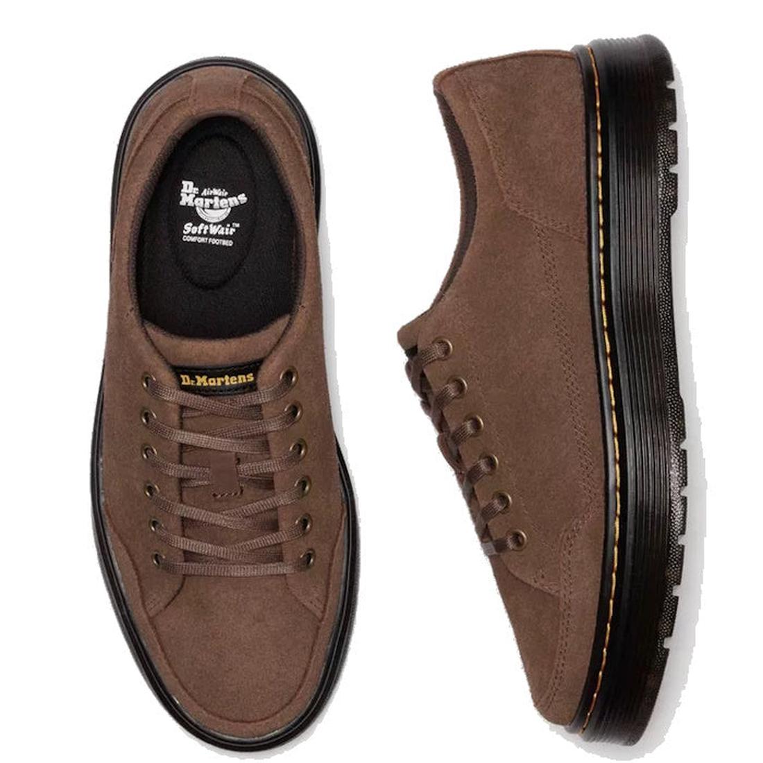 Flay lay of a pair of Brown Dr. Martens Brookline suede shoes on a white background. Showing the top down view of the right foot with it's 6 pair of eyelets and brown laces and 'softwair' fotbed logo on the inner sole. The left foot is on it;s side shoing