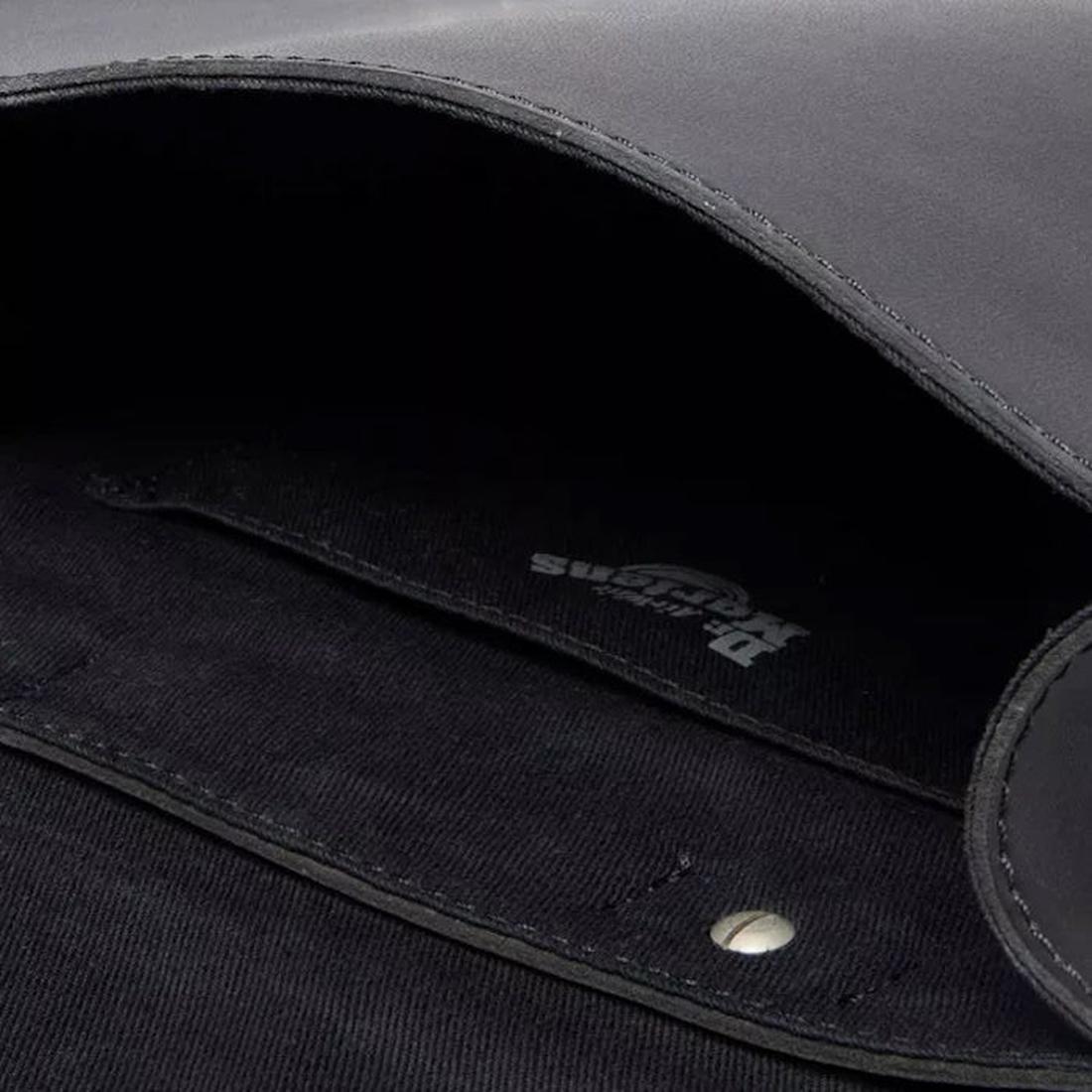 Close-up of the Dr Martens Mini Genix Nappa Solar Flare Leather Backpack Black interior, featuring a fabric lining, metal snap button, and a faintly printed logo on Genix Nappa leather., 190665739695