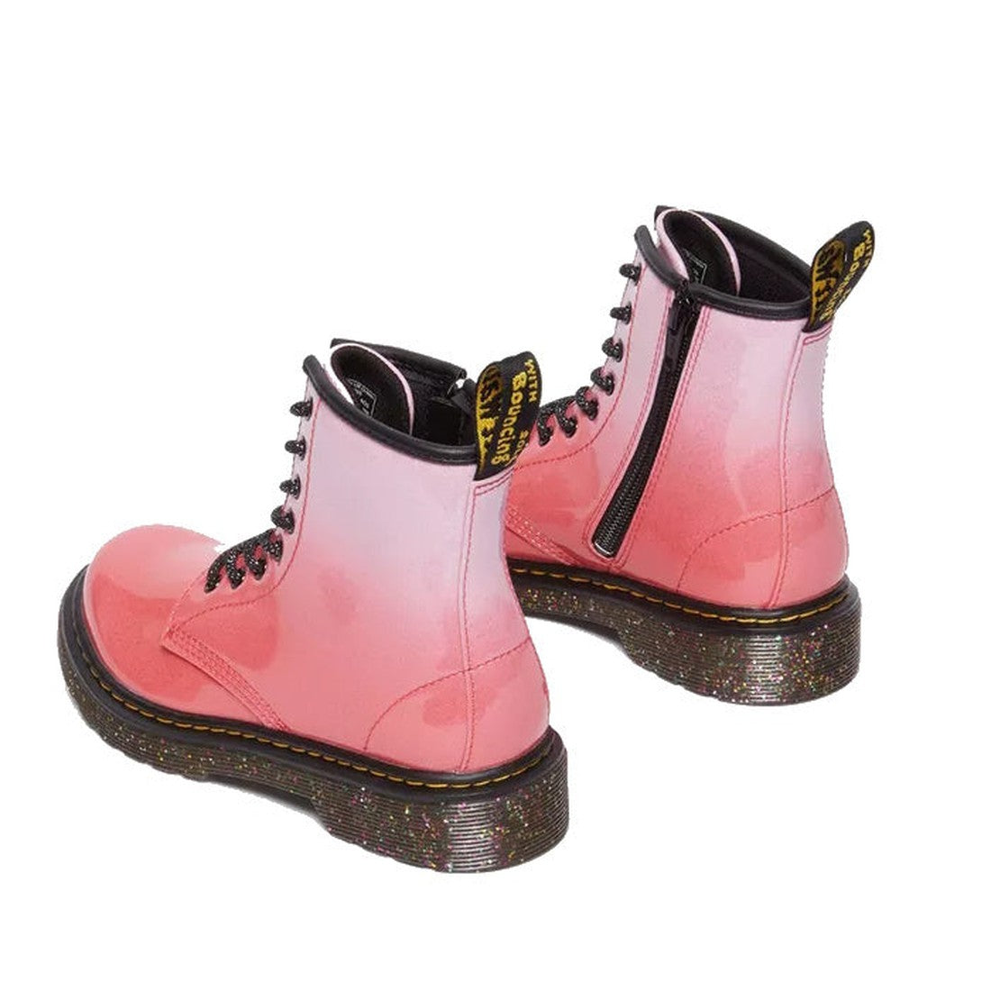 The Dr Martens Kids 1460 Junior Pink Glitter Ombre Gradient boots feature shiny pink ombré glitter, black laces, side zippers, thick speckled soles, and black and yellow pull-tabs on the back., 190665615463, 190665615364, 190665615388, 190665615401