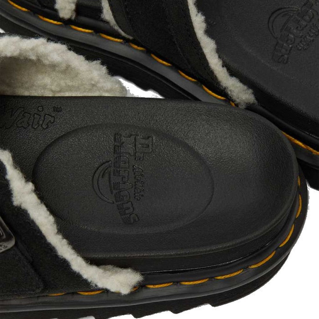 Close-up of Dr Martens - Myles Black Suede Fur Lined Sandal (CLEARANCE) featuring black suede, white faux fur lining, yellow stitching, and embossed Dr. Martens logo on the insole., 25879, 25880, 190665493030, 190665493047, 25883, 190665493061, 1906654930