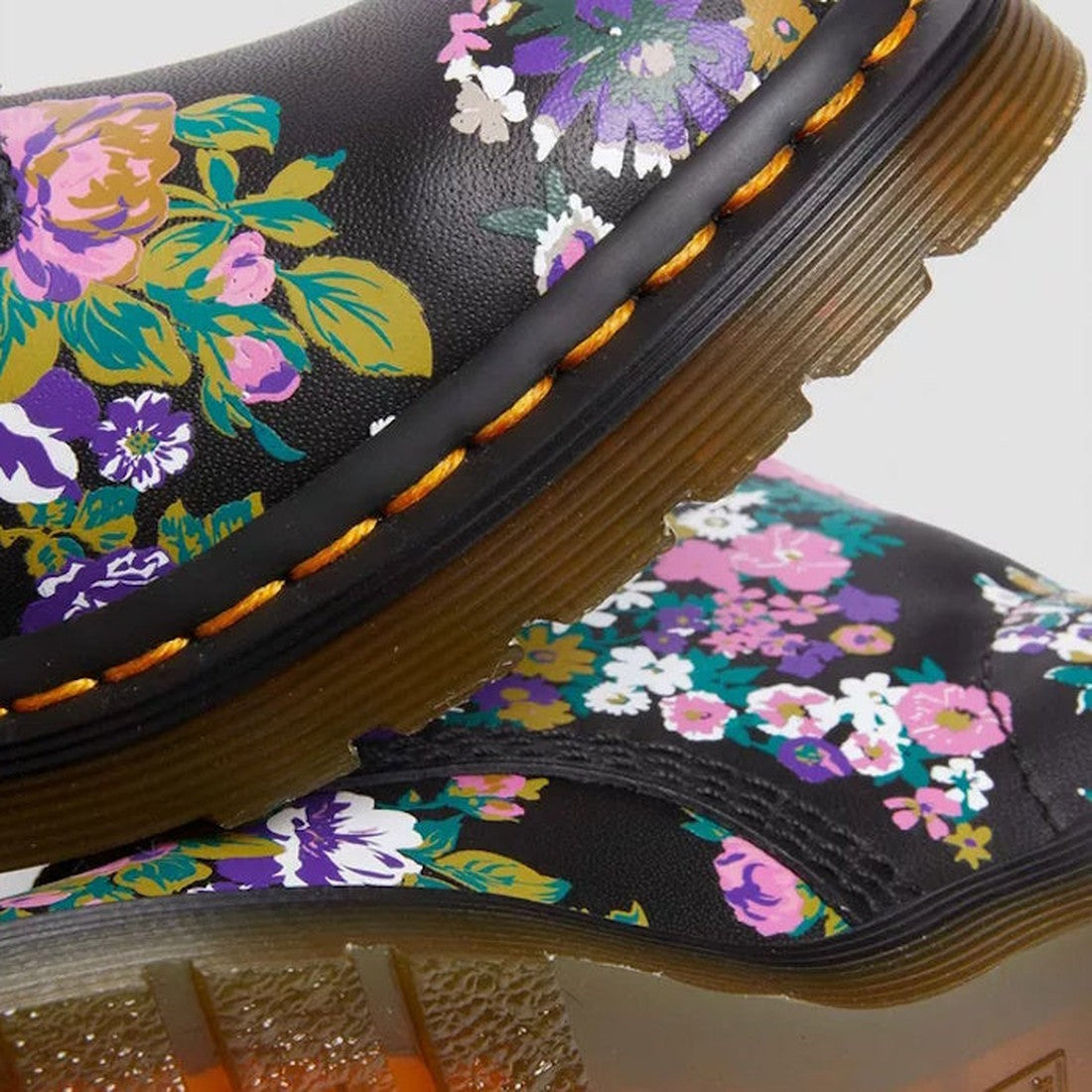 Close-up of Dr Martens Vintage Floral 1460 Pascal Backhand Leather boots in a multi-color floral pattern with translucent soles and orange stitching, shown on clearance., 190665572490, 190665572506, 190665572513, 190665572537, 190665572544, 190665572551
