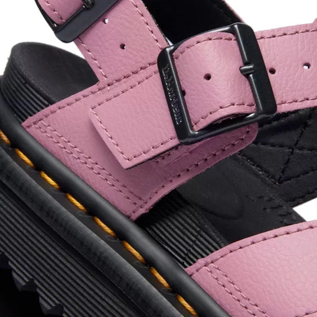 Close-up of the Dr Martens - Voss II Cross Strap Sandal in Dusty Rose Pink, showing a black buckle, thick black sole with yellow stitching, and detailed leather texture with visible tread., 50439, 190665777529, 190665777536, 190665777543, 190665777567, 50