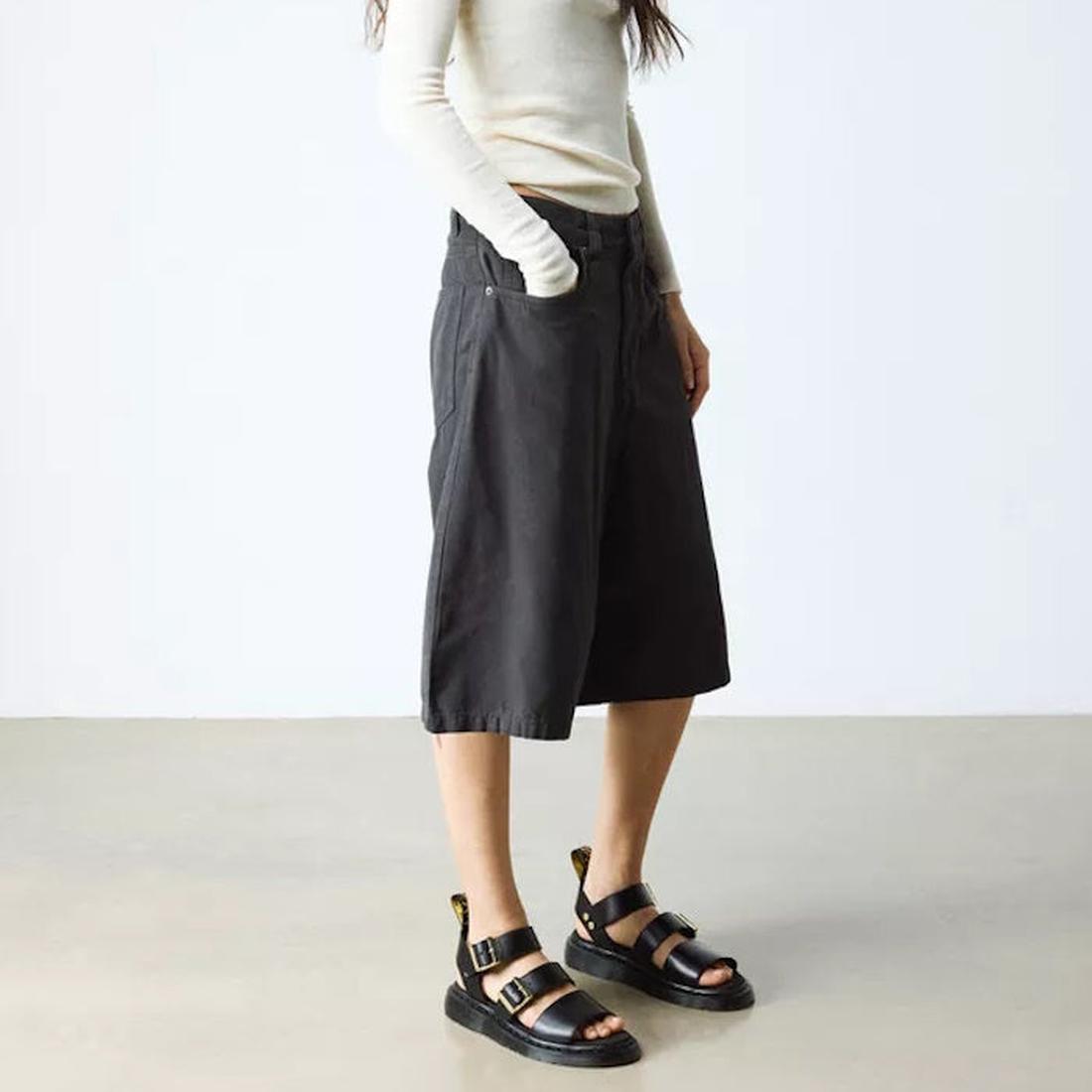A person wears Dr Martens Gryphon Sandal Black Atlas Leather, featuring black straps and buckle closure, on a simple white backdrop.  ksnz, 190665783414, 190665783421, 190665783438, 190665783452, 190665783469, 50536