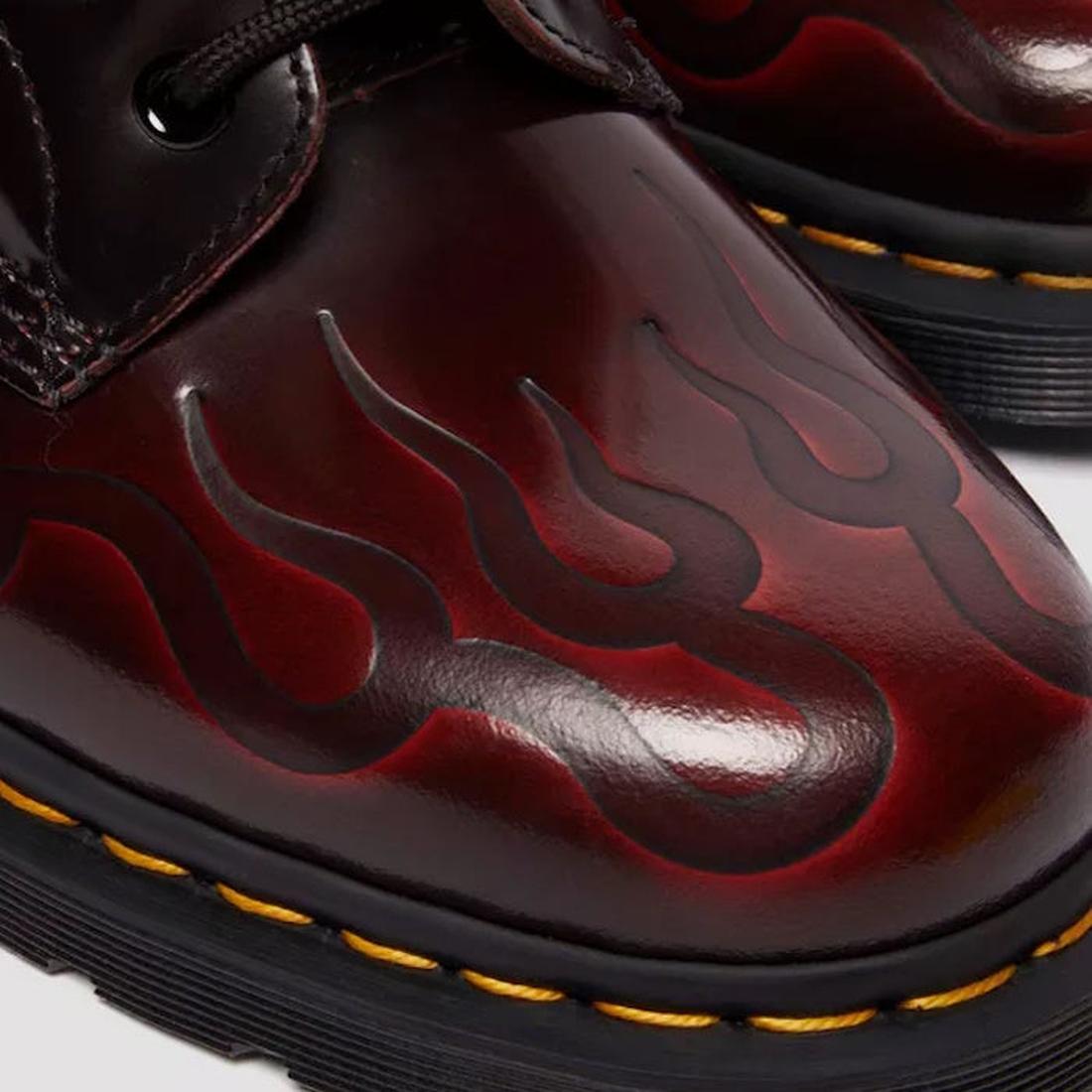 Close-up of the toe of the right foot of  a red leather Dr Martens 1460 boot with embossed flame design  a white background,
190665743081,
190665743098,
190665743104,
190665743128,
190665743135,
190665743142,
190665743166,, 190665743081, 190665743098, 190