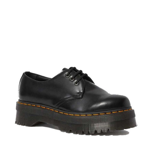 Dr Martens 1461 Quad Polished Black Shoe is a stylish lace-up with a sturdy platform sole and bright yellow stitching, on white.  ksnz