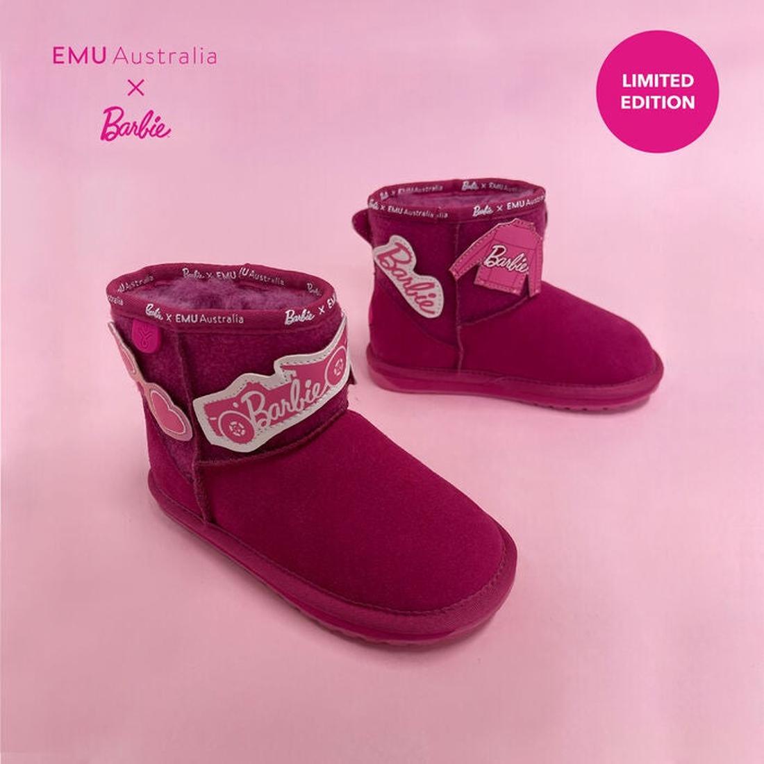 Two vibrant EMU Kids Wallaby Mini Play Barbie Pink boots with Barbie logos and patterned trim, crafted from premium Australian Merino wool, sit on a pink backdrop. A pink circle in the corner reads LIMITED EDITION.