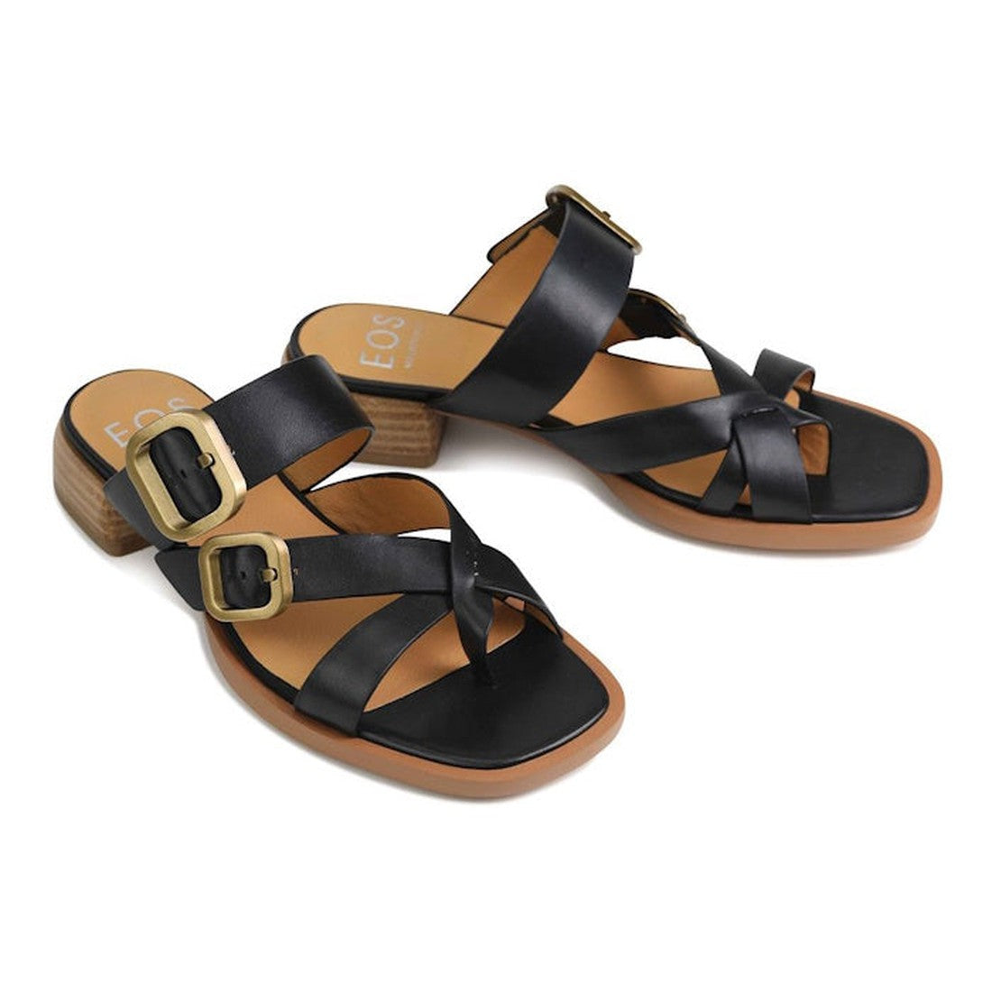 The EOS Teia Black Low Heeled Sandal Slide features black cashmere leather, wide crisscross straps with two large gold buckles per sandal, tan insoles, and low, chunky block heels with a wood-like texture., 9321191143897, 9321191143903, 9321191143910, 337