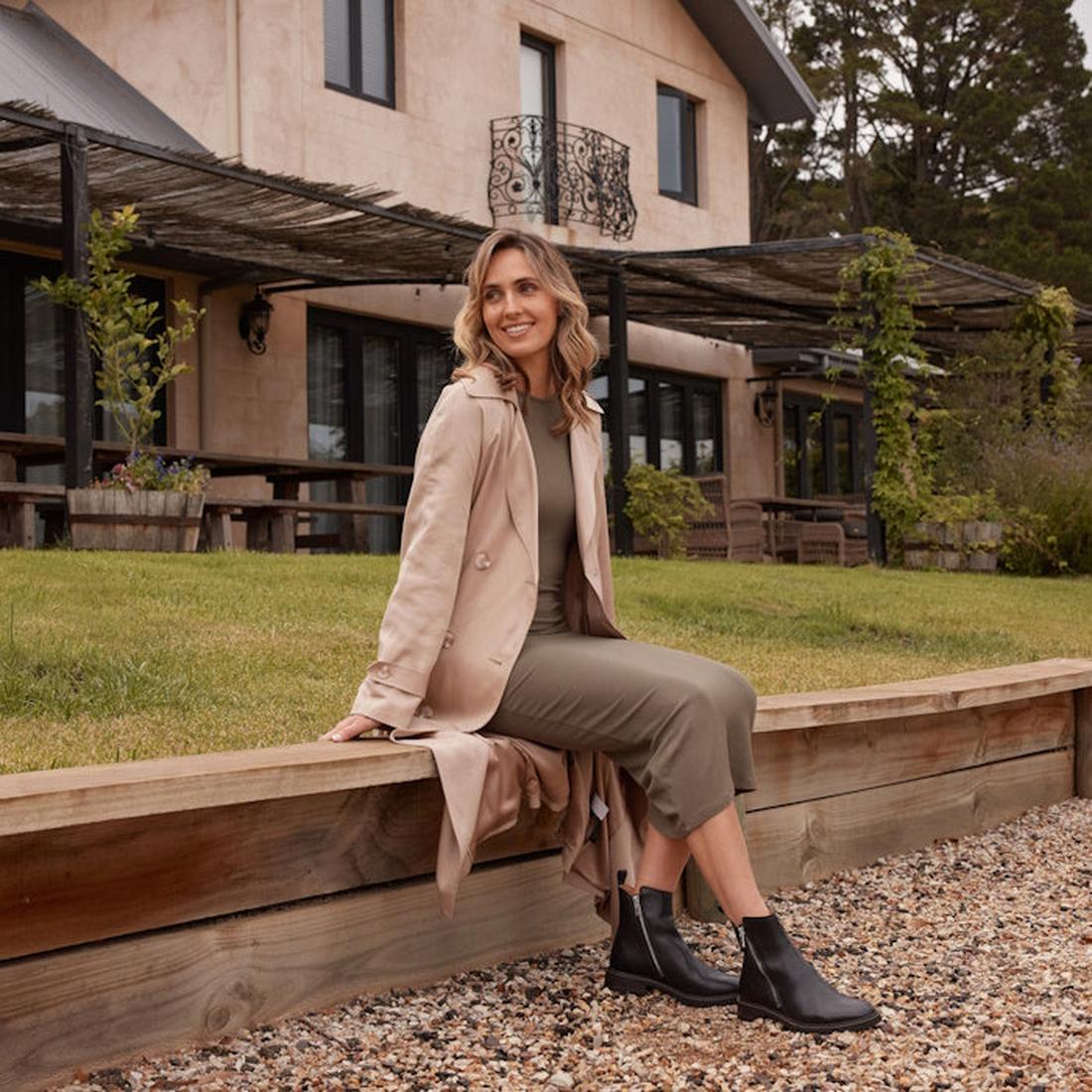 A model sittimg wear the EOS womens black blaine ankle boot showing teh zips on the inside and the outside of the foot.,
9321191186962,
9321191186979,
9321191186986,
9321191186993,
9321191187006,, 9321191186962, 9321191186979, 9321191186986, 9321191186993