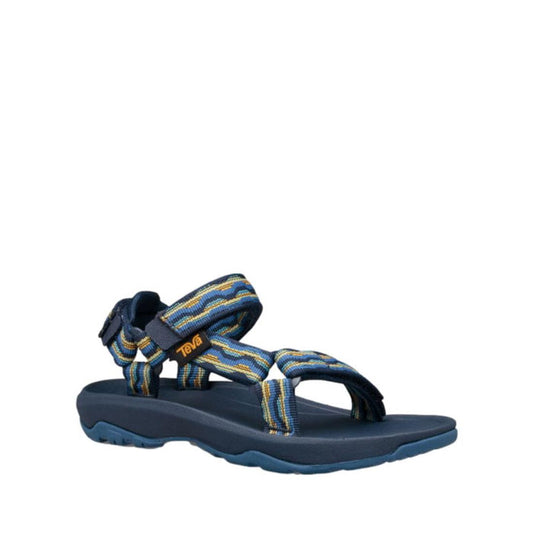 The Teva Kids K Hurricane XLT2 Kishi Dark Blue is a hiking sandal with multicolored recycled straps, a thick textured sole, hook-and-loop closure, and branded tag.