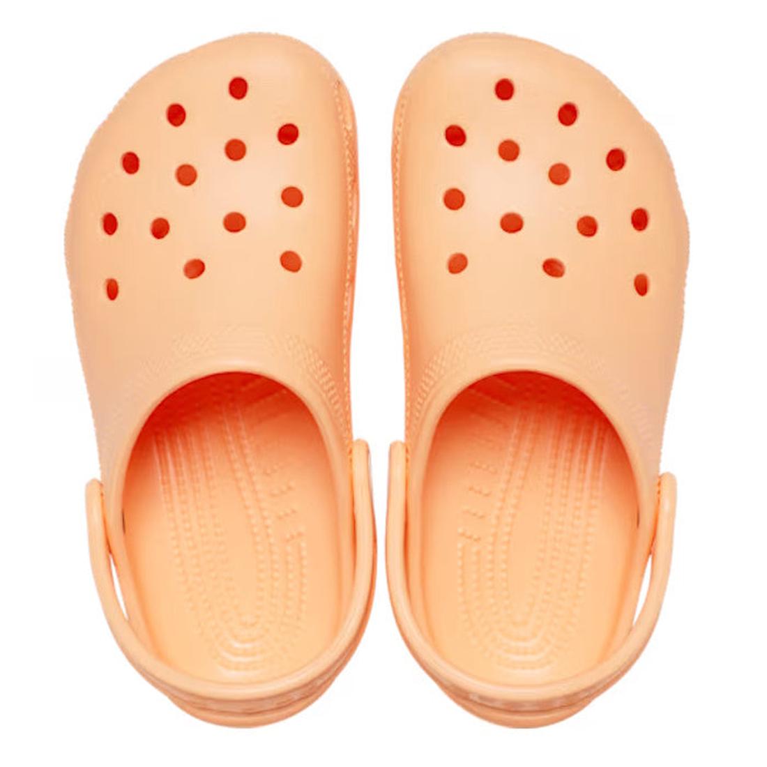 A pair of Crocs Kids Classic Clog in Sunstone Soft Orange for junior youths, featuring ventilation holes and adjustable heel straps, shown from above on a white background., 198445270154, 198445270161, 198445270178, 198445270185, 198445270192, 19844527020