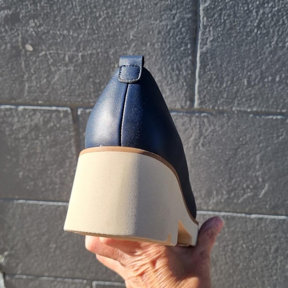 The One Trick Pony Newness Navy Leather Women's Chunky Loafer, with an easy pull-on loop and sturdy light sole, held by hand.  ksnz, 44049, 44050, 44051, 44052, 44053, 44054, 44055