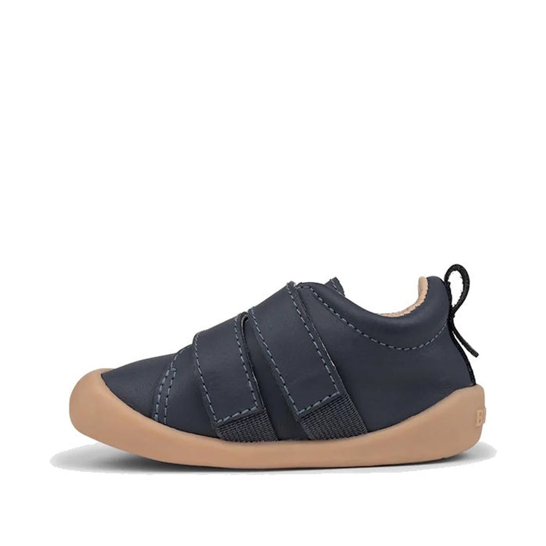 The Pretty Brave First Walker Toto Leather Trainer in Indigo Blue is a flexible baby shoe with two hook-and-loop straps, tan rubber sole, visible stitching, and a black heel pull tab—perfect for first walkers. Displayed on a white background., 94200753662