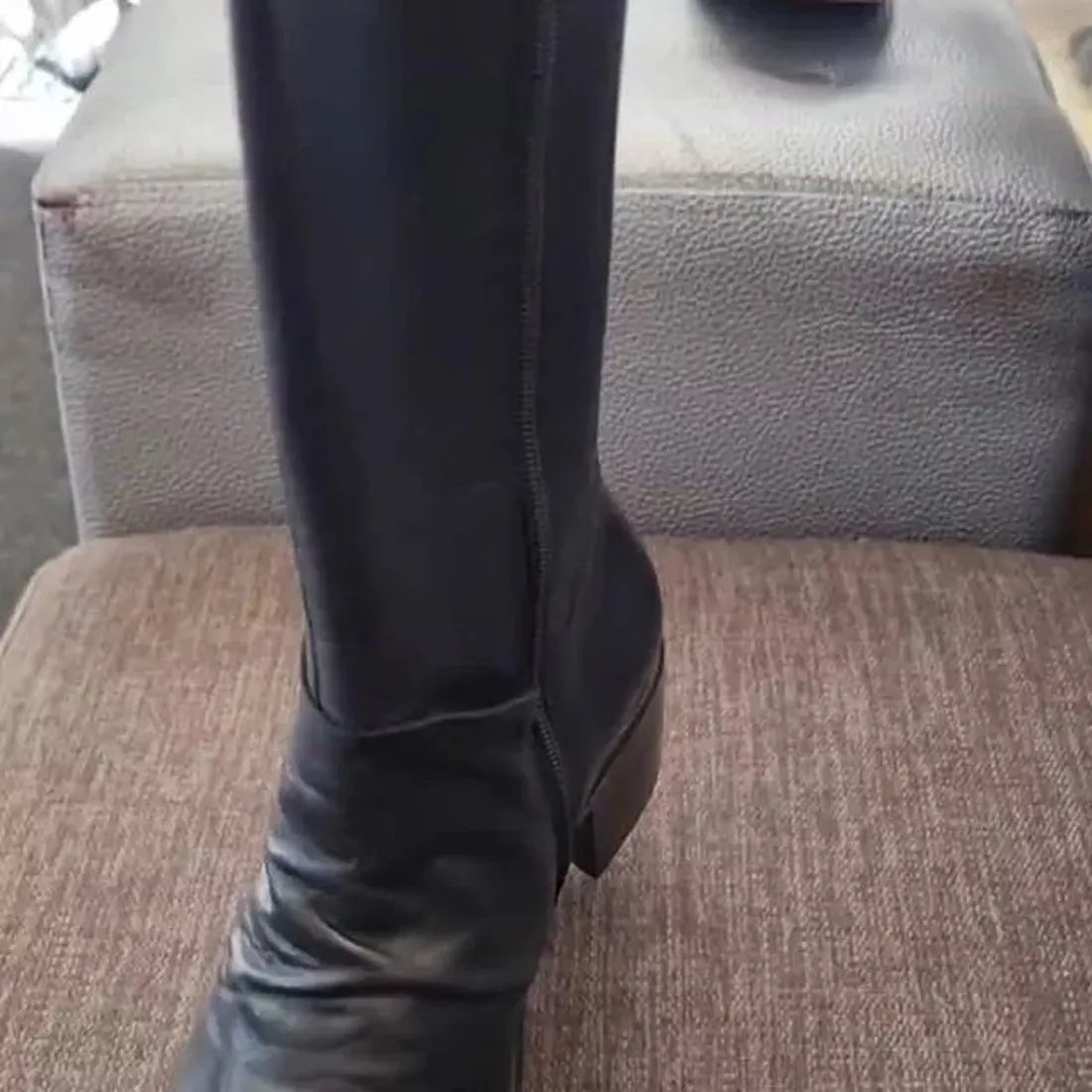 EOS Rochelle Black Soft Leather High Boot—classic black, sturdy heel, comfy sole, easy side zip—rests on a brown cushioned bench.  ksnz, 9321191199009, 9321191199016, 9321191199023, 9321191199030, 9321191199047
