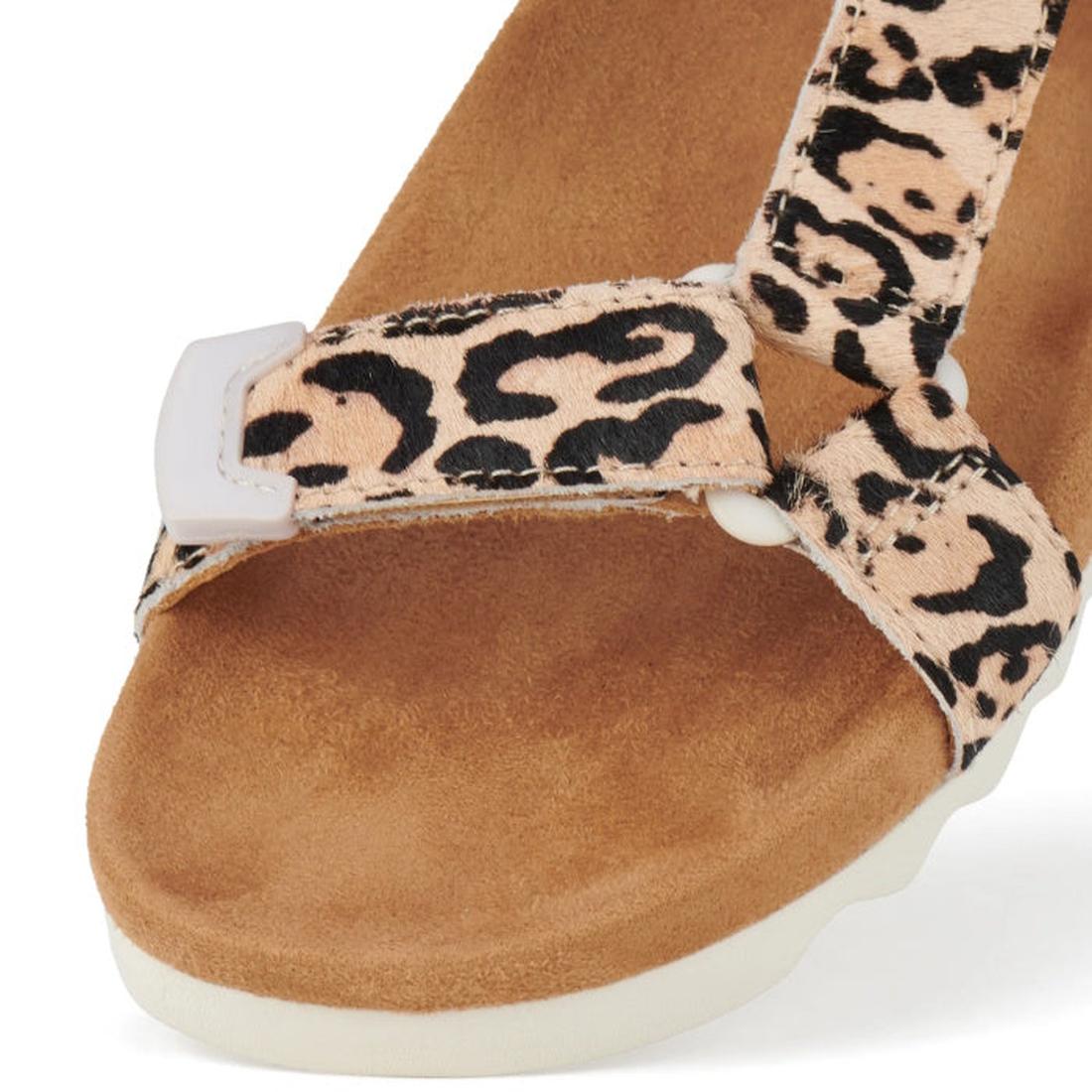 A close-up of the Rollie Womens Sandal Tooth Wedge Neutral Leopard showcases its suede-wrapped footbed, beige and black leopard print strap, white toe accent, adjustable leather strap, and textured light-colored sole., 9382771798722, 9382771798739, 938277