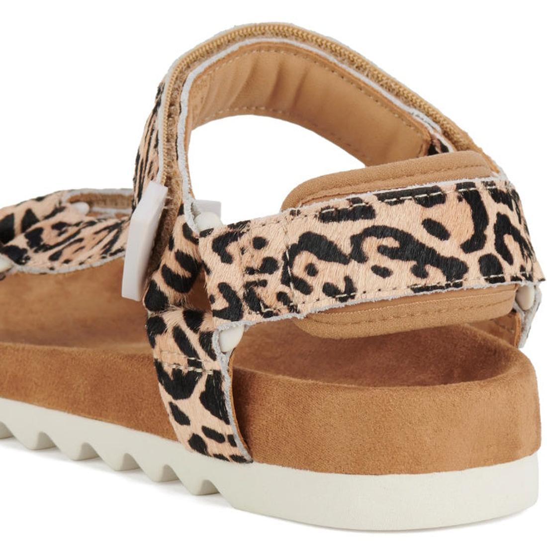 A close-up of the Rollie Womens Sandal Tooth Wedge Neutral Leopard, showcasing its tan and black leopard print, cushioned suede-wrapped footbed, white jagged sole, and adjustable Velcro straps., 9382771798722, 9382771798739, 9382771798746, 9382771798753, 