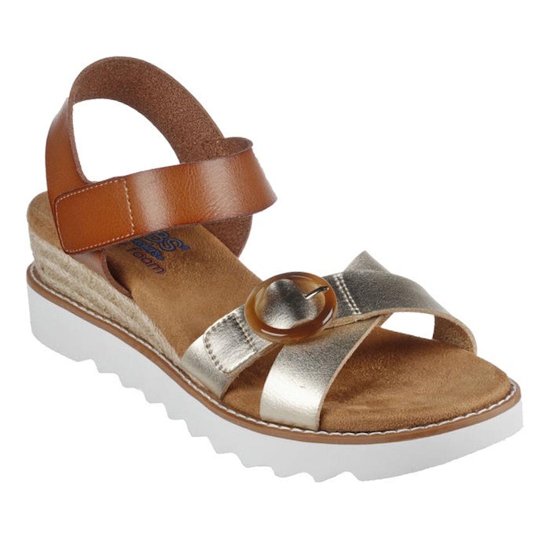 The Skechers Bobs Womens Desert Kiss Hi Divine Garden Champagne Tan features a brown ankle strap, metallic gold crisscross straps, circular buckle, memory foam footbed, white wedge sole with jagged tread, and vegan materials.