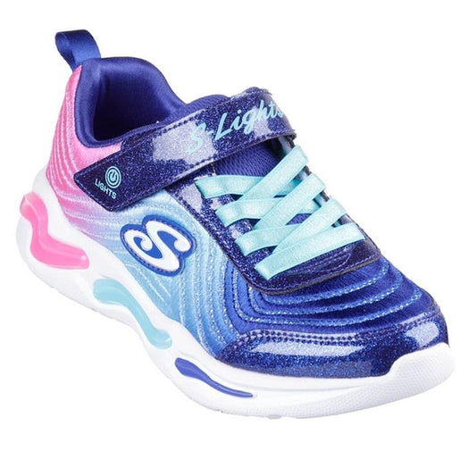 The Skechers Girls Light Ups - Wavy Beams Ombre Express Navy Multi is a colorful trainer with a blue and purple glitter ombre design, light blue laces, S Lights Velcro strap, and pink-blue accents on a white sole.
