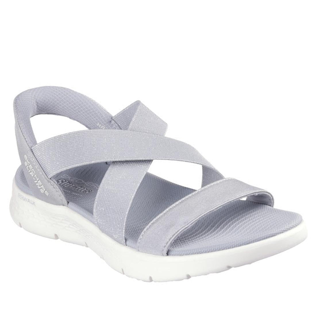 The Skechers Womens Slip Ins Sandals Go Walk Flex Glimmer Up Grey feature crisscross fabric straps in light gray and a thick white cushioned sole, offering comfortable and casual style for everyday wear.