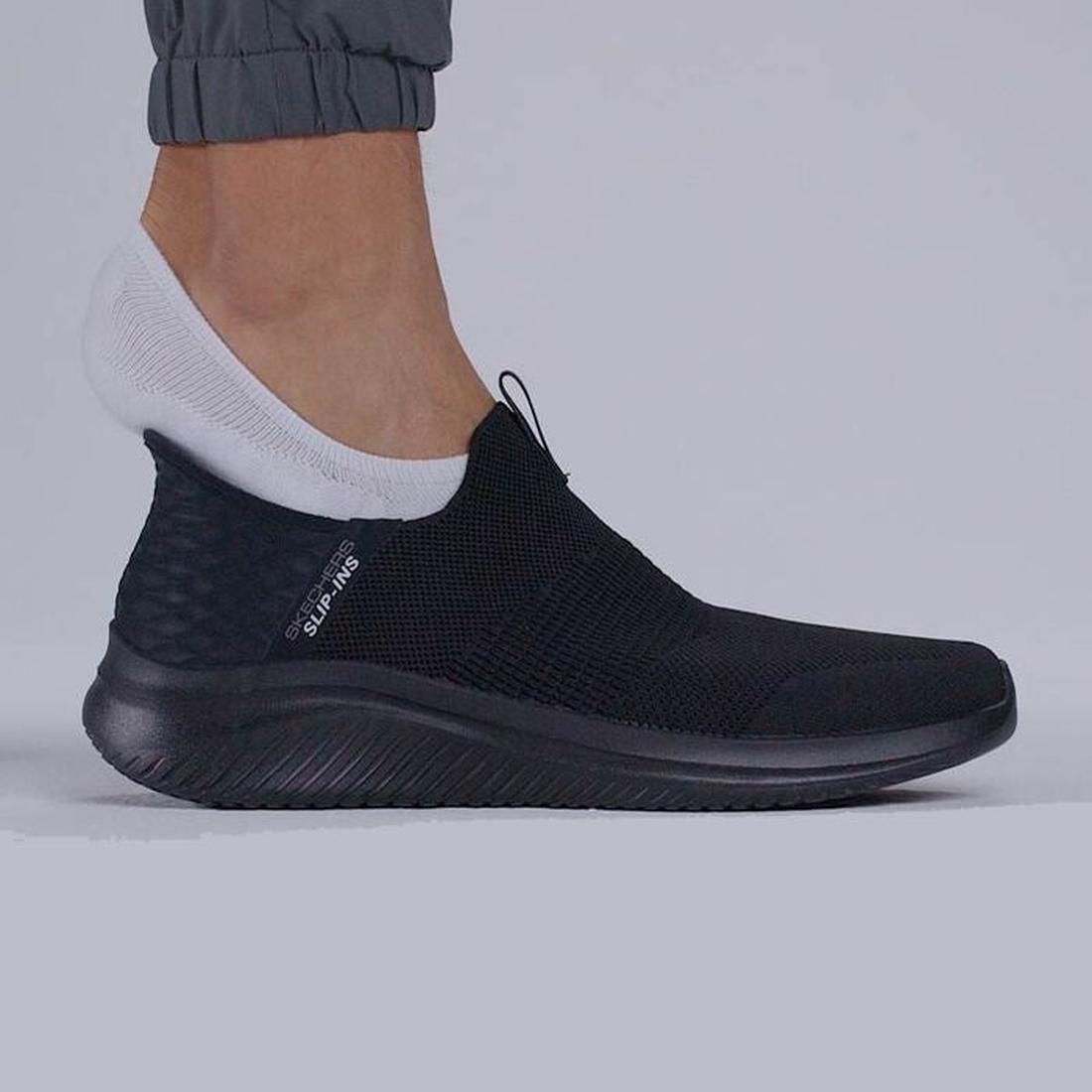 A person in gray jogger pants and white ankle socks wears the Skechers Mens Slip Ins Ultra Flex 3.0 Viewpoint shoe, featuring a textured sole, mesh upper, and Air-Cooled Memory Foam, standing on a light gray surface., 38456, 196311463709, 196311463723, 38