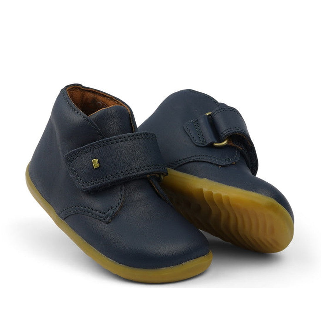 A pair of navy blue Bobux Step Up Desert Boots with large velcro straps and a simple design.