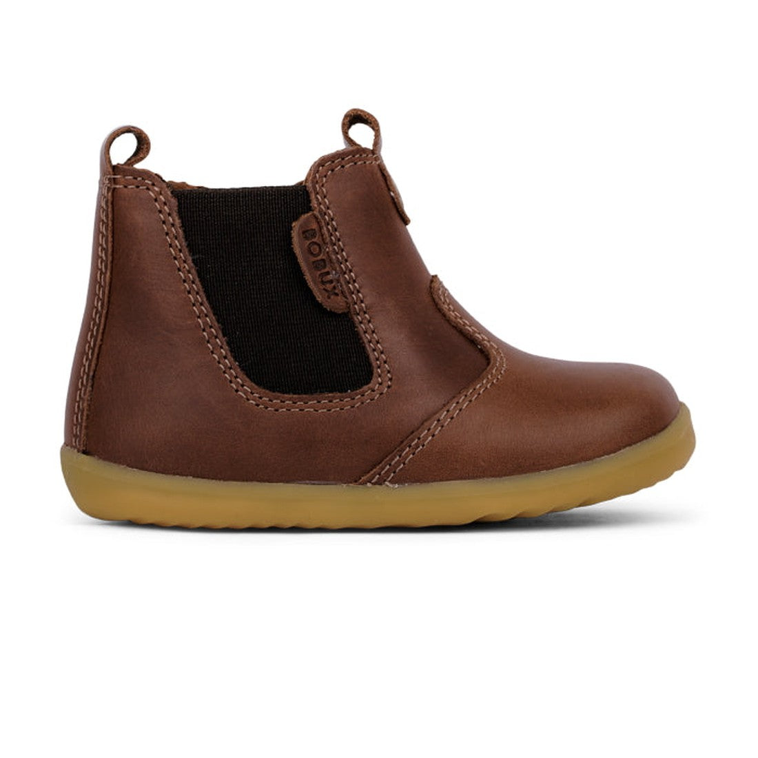 The Bobux Step Up Jodphur Boot Toffee 721926A is a unisex brown leather children’s boot with elastic side panels, pull tab, and light brown rubber sole—ideal stylish first walkers. Displayed in side profile on a white background., 9420062048382, 942006204