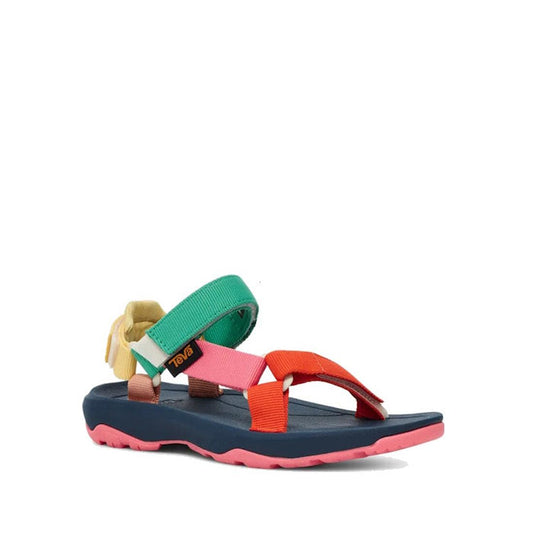 The Teva Kids K Hurricane XLT2 Popcorn Multi is a hiking sandal with a navy blue sole, pink tread, and multicolored straps in green, orange, yellow, and pink. Crafted from recycled materials and finished with a Teva logo on the side strap.